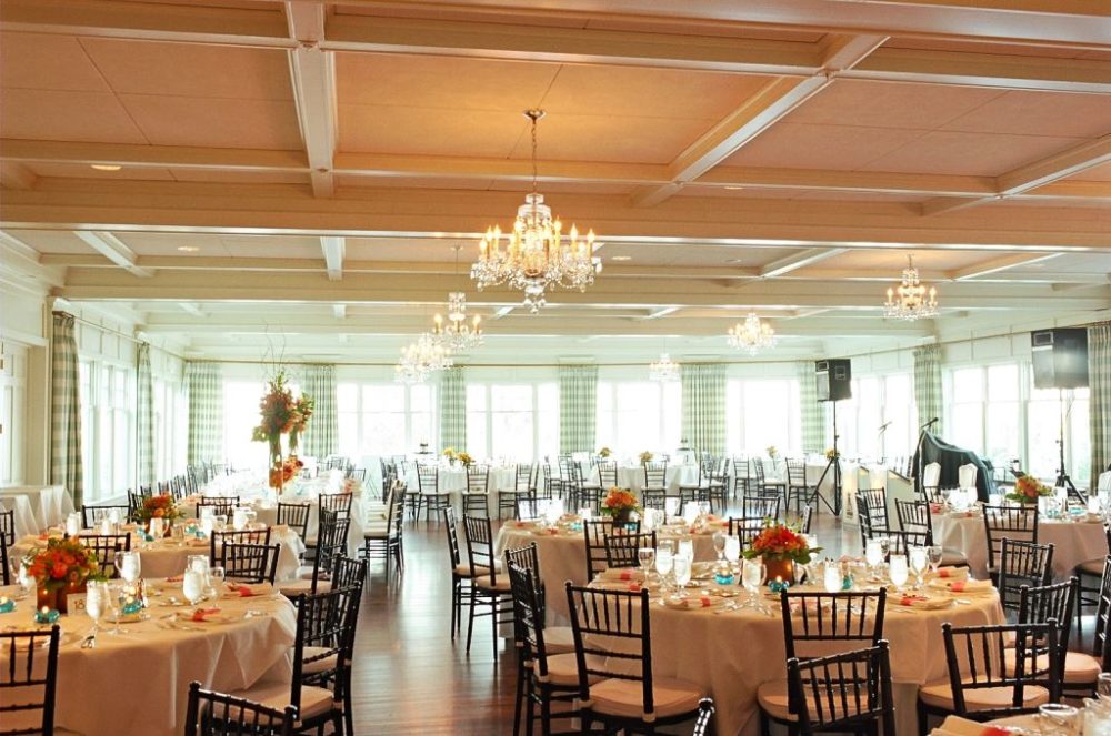 Decorated reception tables in an upscale room with chandeliers